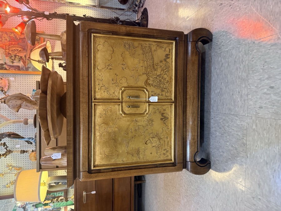 A Hollywood Regency chinoiserie credenza with gold hand-painted doors, photographed in an antique shop
